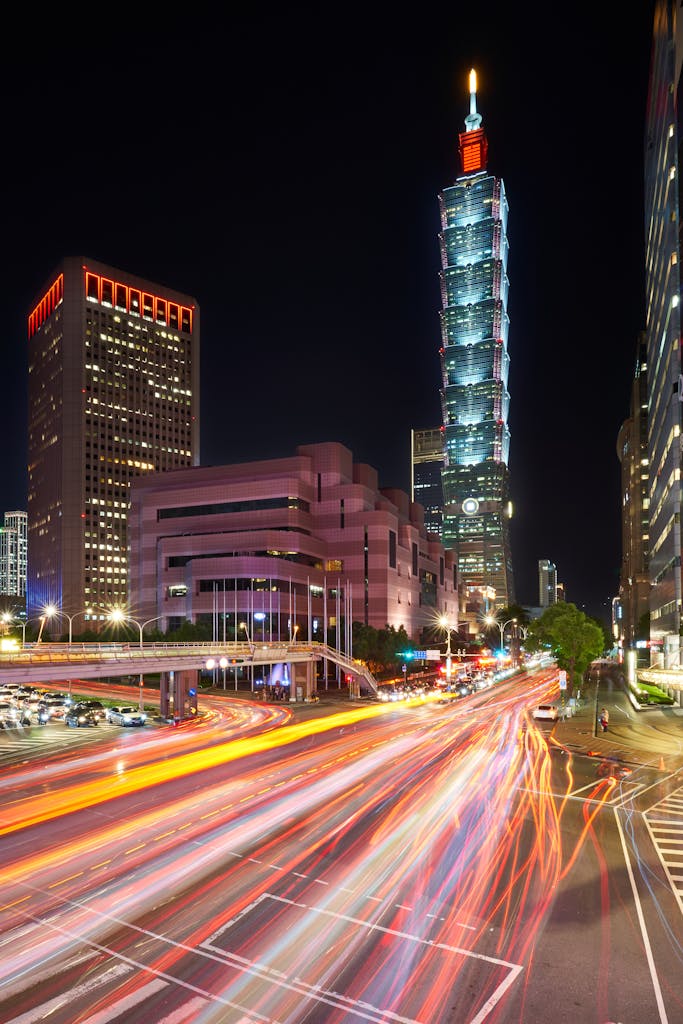 Explore lively Taipei with stunning views of Taipei 101 and dynamic light trails in the urban nightscape.