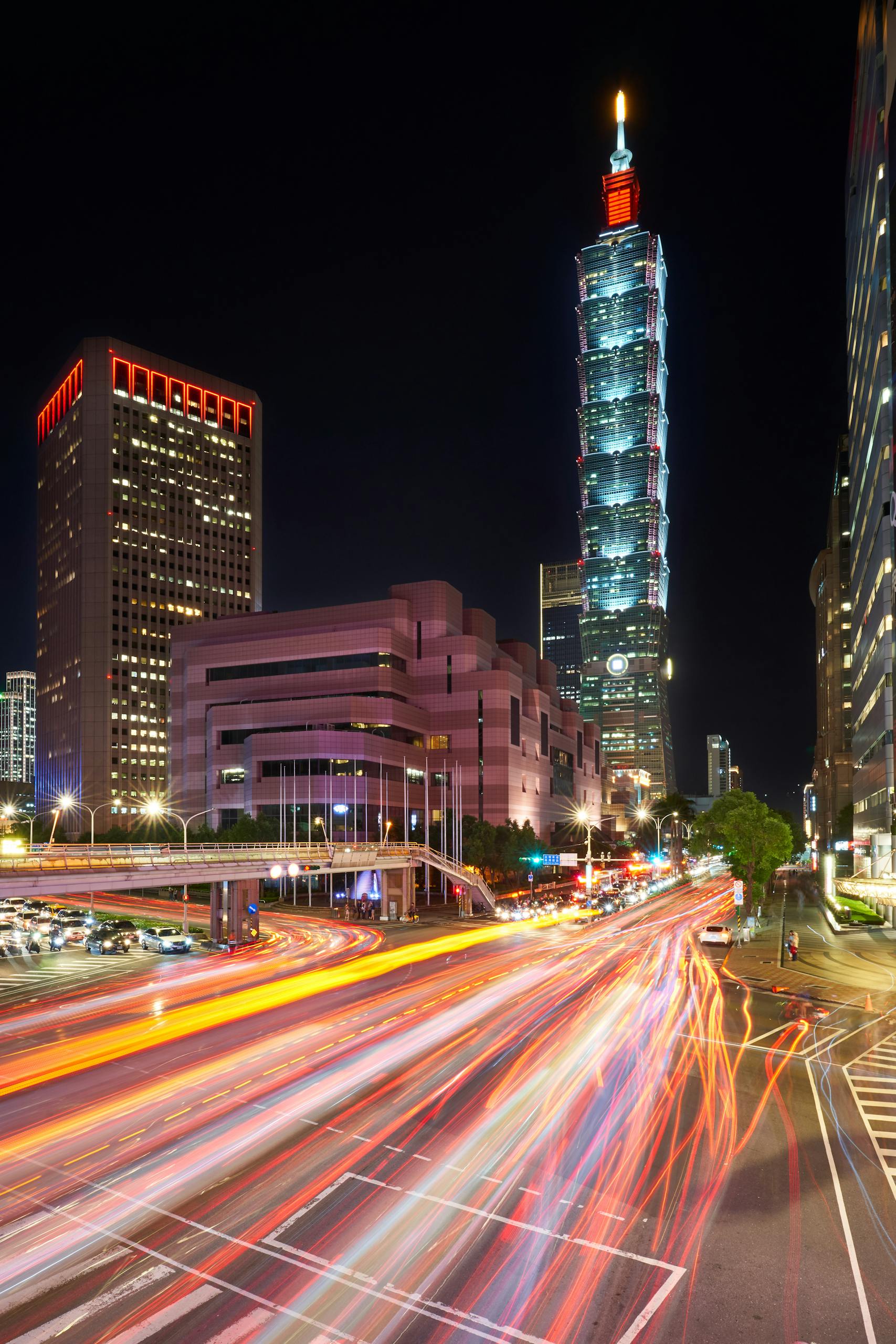 Explore lively Taipei with stunning views of Taipei 101 and dynamic light trails in the urban nightscape.